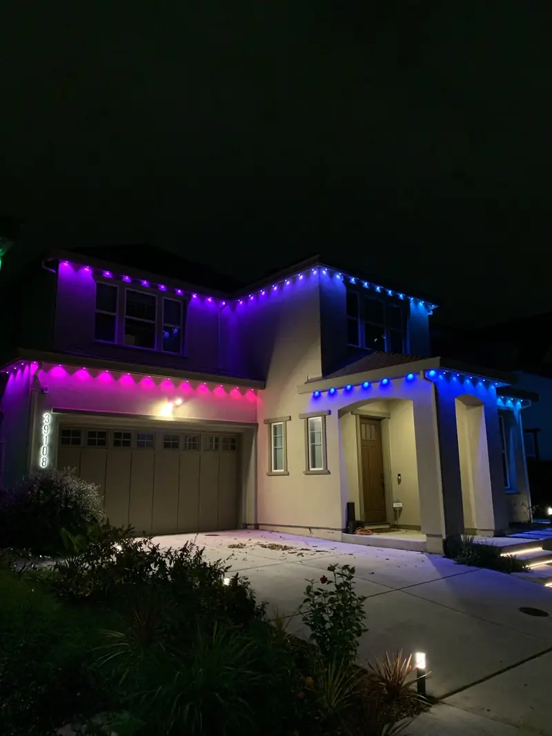 Two-story home with purple and blue roofline lights