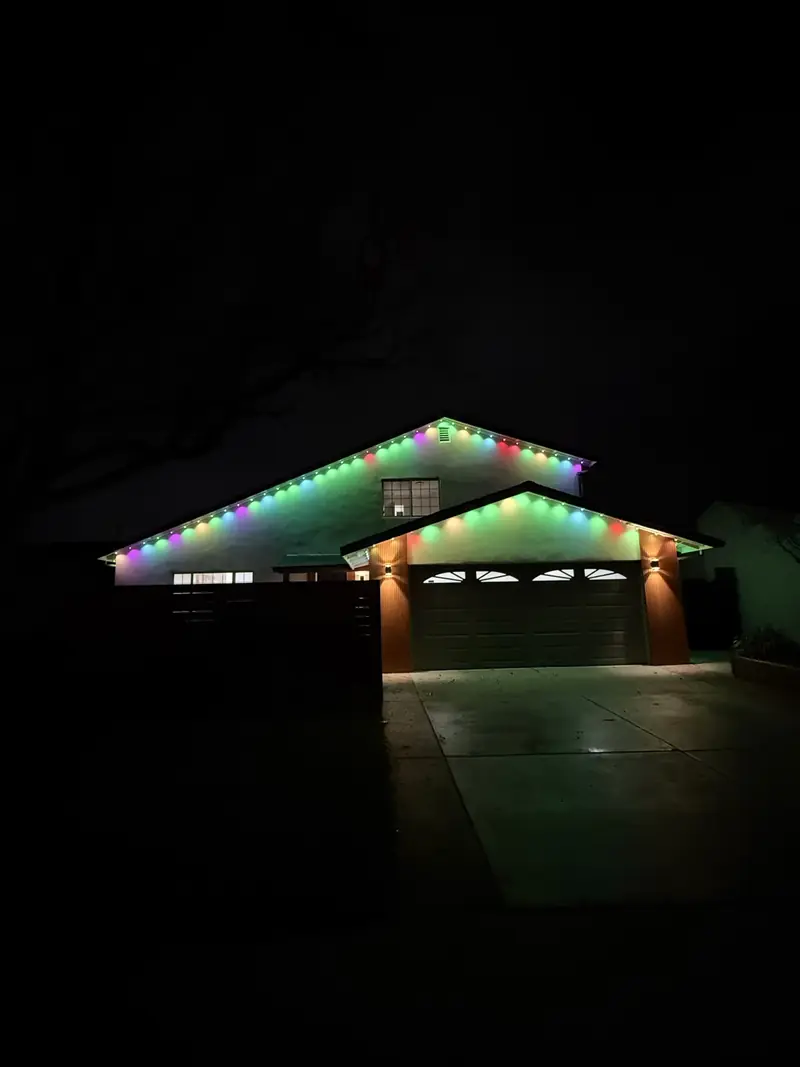 Single-story home with multicolor lights on the roof gables